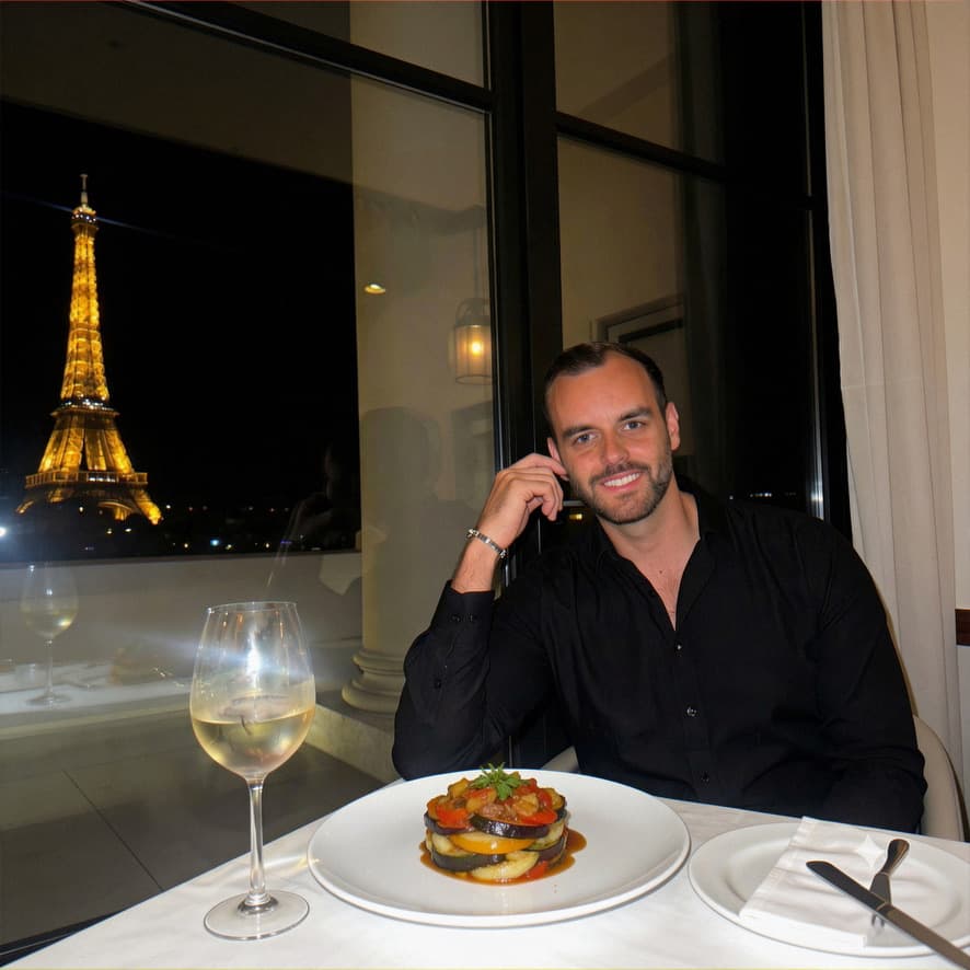 Mand på en restaurant i Paris med Eiffeltårnet i baggrunden — eksempel på rejse/miljøshot