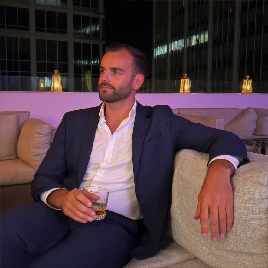 Homme dans un costume bleu marine sur une terrasse-bar — exemple de photo habillée pour un profil de rencontre